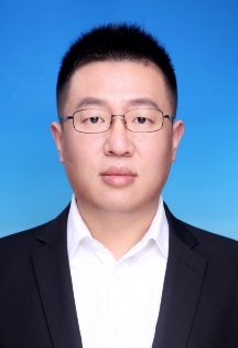 A person in a suit and glasses Description automatically generated